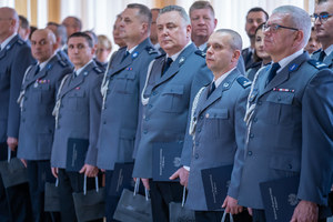 Policjanci stoją w rzędzie w sali konferencyjnej