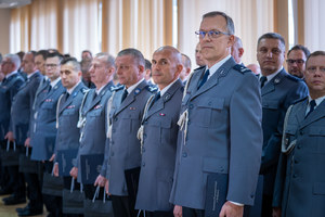 Policjanci stoją w rzędzie w sali konferencyjnej