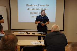 policjant prowadzi wykład na sali