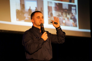 policjant prowadzi konferencję na scenie