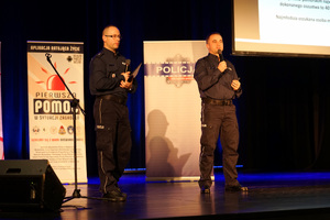 policjant prowadzi konferencję na scenie