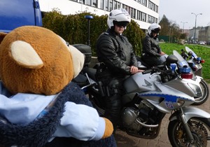 policjanci na motorach patrzą na pluszowego misia