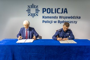 mężczyzna i komendant podpisują dokumenty