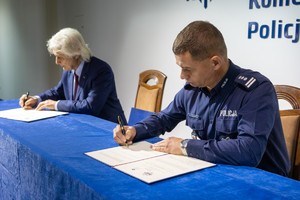 mężczyzna i komendant podpisują dokumenty