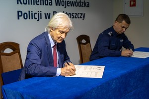mężczyzna i komendant podpisują dokumenty