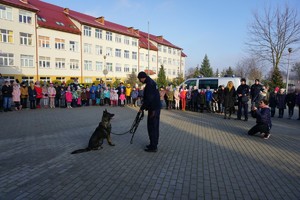 policjant pokazuję dzieciom tresurę psa służbowego