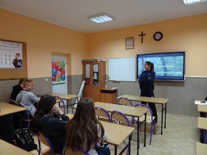 Policjantka przemawia do uczniów siedzących w ławkach