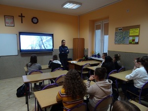 Policjantka przemawia do uczniów siedzących w ławkach