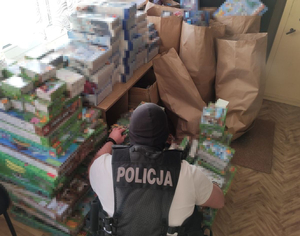 policjant kuca przy stosie zabawek