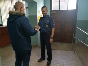 Policjant przekazuje odzyskany portfel właścicielowi