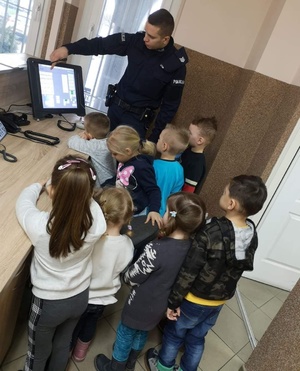 Policjant rozmawia z dziećmi w komisariacie