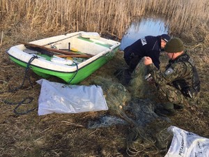 Policjant i strażnik rybacki zabezpieczają sieci