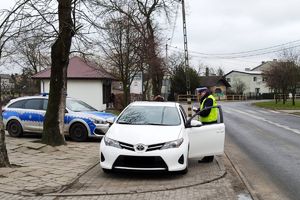 Policjant RD kontroluje kierowcę toyoty, w pobliżu zaparkowany radiowóz