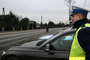 Policjant RD stoi obok radiowozu - patrol w ramach NURD