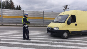 Policjant sprawdza światła w żółtym dostawczaku
