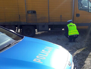 Policjant zagląda pod auto dostawcze