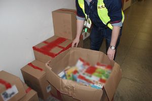 Policjant eksponuje karton ze skradzionymi puzzlami