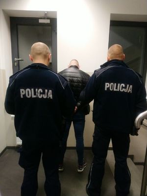 Policjanci prowadzą zatrzymanego 25-latka