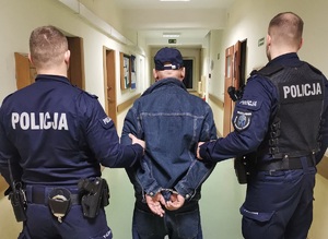 Policjanci prowadzą sprawcę kradzieży rozbójniczej