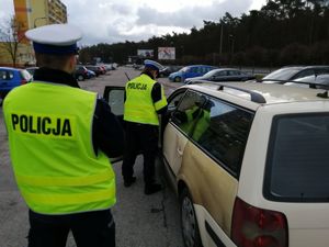 Policjanci kontrolują kierowcę zatrzymanego za przekroczenie prędkości