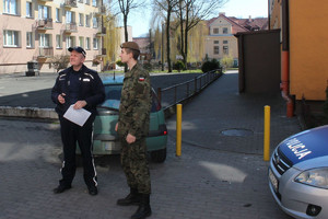 Policjant i żołnierz Wojsk Obrony Terytorialnej podczas sprawdzania adresu kwarantanny.