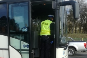 Policjant kontroluje autobus.