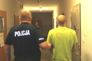 Policjant prowadzi zatrzymanego mężczyznę