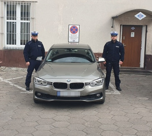 dwaj policjanci ruchu drogowego stoją obok radiowozu marki BMW