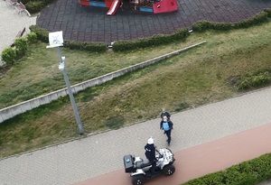 widok z drona z góry na policjanta jak na quadzie rozmawia z mężczyzną i kobietą na chodniku