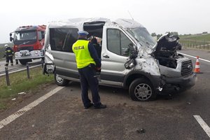 Policjant stoi nad rozbitym samochodem