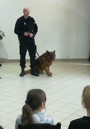 policjant prezentuje umiejętności psa służbowego