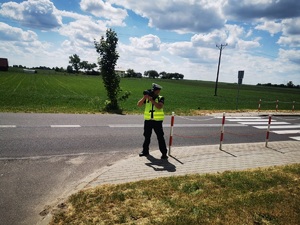 Policjant mierzy prędkość przy drodze
