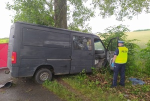 policjant stoi przy rozbitym samochodzie