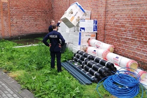 Policjanci przy zabezpieczonych materiałach budowlanych. (2)
