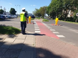 Policjant stoi przy przejeździe dla rowerzystów