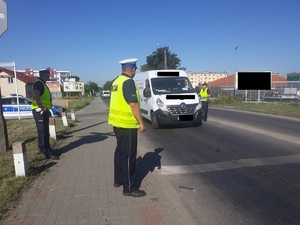 Policjanci RD stoją przy przejeździe, a SOKista rozmawia z kierowcą