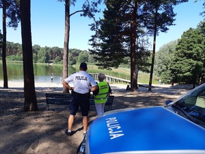 Policjant z przedstawicielką Sanepidu nad jeziorem