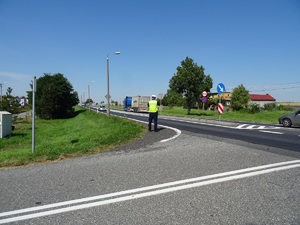 Policjant RD na skrzyżowaniu mierzy prędkość auta