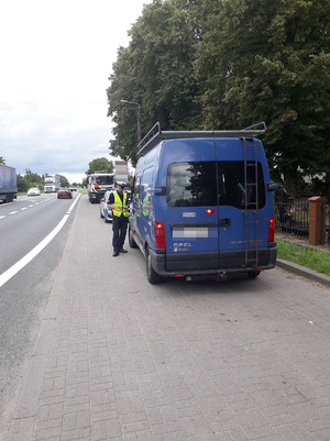 Policjant wykonuje kontrolę drogową