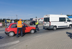 policjant kontroluje pojazd przy przejeździe kolejowym