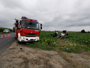 Opel vectra stoi w polu, obok wóz strażacki, a na poboczu radiowóz