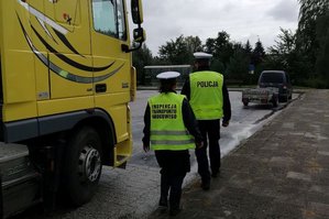 Policjant RD i funkcjonariuszka ITD idą skontrolować kierowcę TIR&#039;a