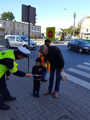 Policjant RD daje dziecku odblask