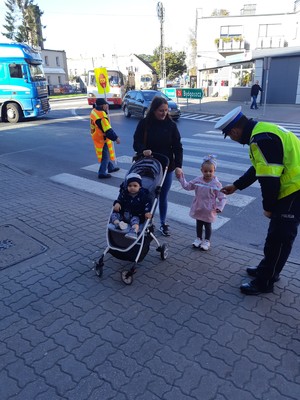 Policjant RD daje odblask małej dziewczynce