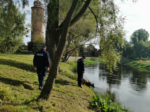 Policjanci nad brzegiem rzeki.