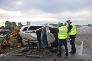 dwóch policjantów stoi przy rozbitym samochodzie