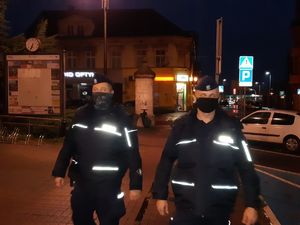 Patrol policjantów na ulicy nocą.