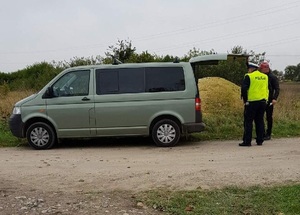 Policjant i kierowca przy busie.