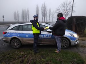 Policjant przekazuje mężczyźnie odblaski