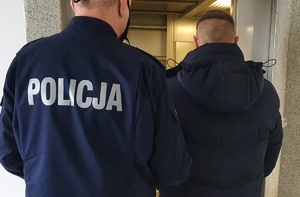 Policjant prowadzi zatrzymanego mężczyznę